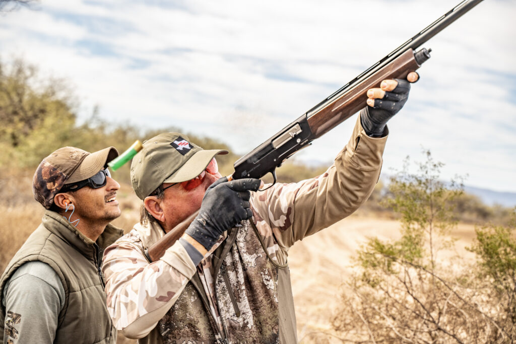 Bird boy assisting a hunter during a dove hunting excursion in Argentina.