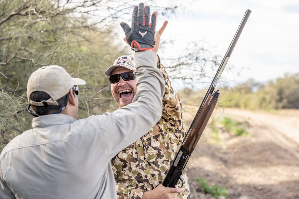 Hunter celebrating a successful dove hunt with a bird boy in Córdoba, Argentina
