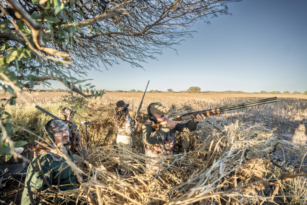 Hunters and bird boys positioned in a field during a dove hunting experience in Córdoba, Argentina.