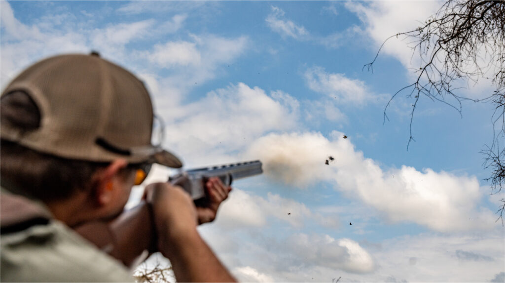 Hunter aiming a shotgun during an Argentina dove hunting experience.
