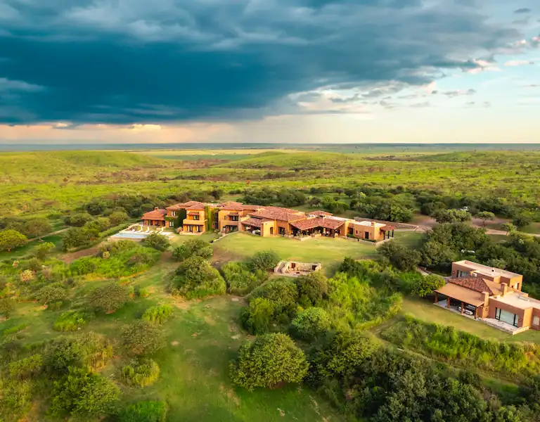 Aerial view of Guayascate Lodge among green hills and native woodland in Córdoba, Argentina